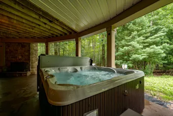 Outdoor hot tub on the patio at Woodland Chalet — guest-controllable through the Lakehearth app